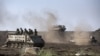 An Israeli Armored Personnel Carrier (APC) and Merkava tanks maneuver during a drill in the Israeli annexed Golan Heights near the border with Syria on May 6, 2013.