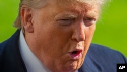 FILE - President Donald Trump speaks to journalists outside the White House, Nov. 3, 2019, in Washington, as he returns from a weekend trip to New York. Trump spoke about the whistleblower in the impeachment probe into Trump's dealings with Ukraine.