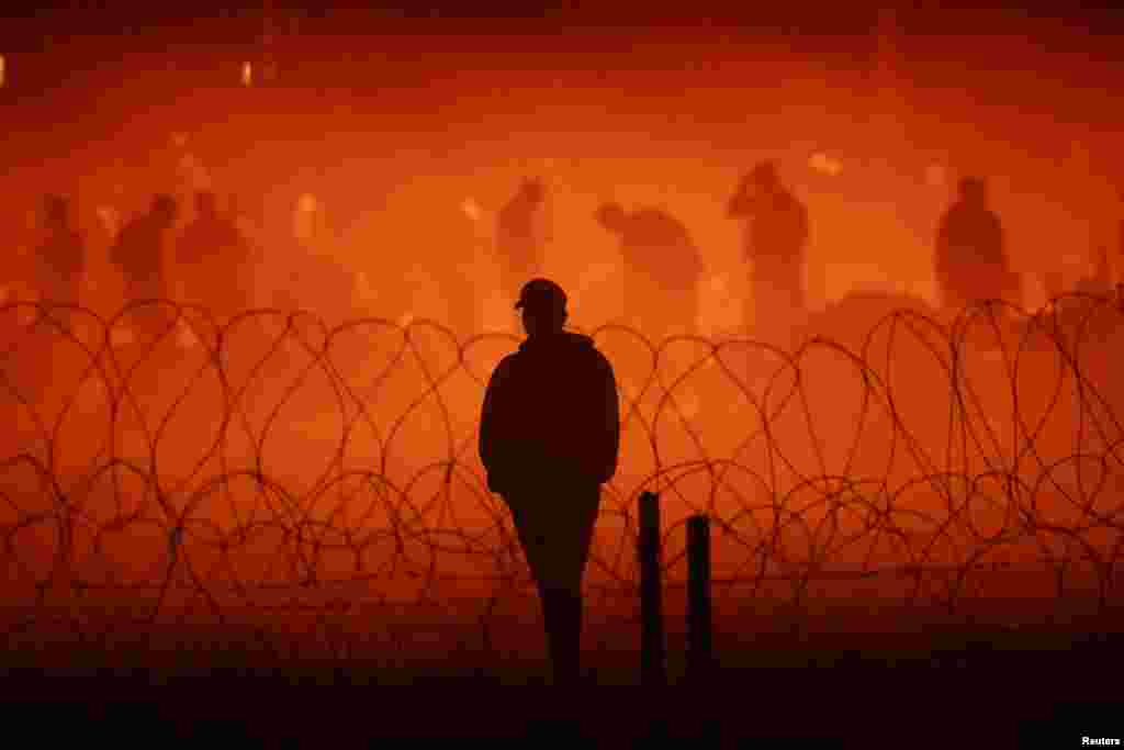 Migrants gather near the border wall after crossing the Rio Bravo River with the intention of turning themselves in to the U.S. Border Patrol agents to request asylum, as seen from Ciudad Juarez, Mexico, Sept. 25, 2023.
