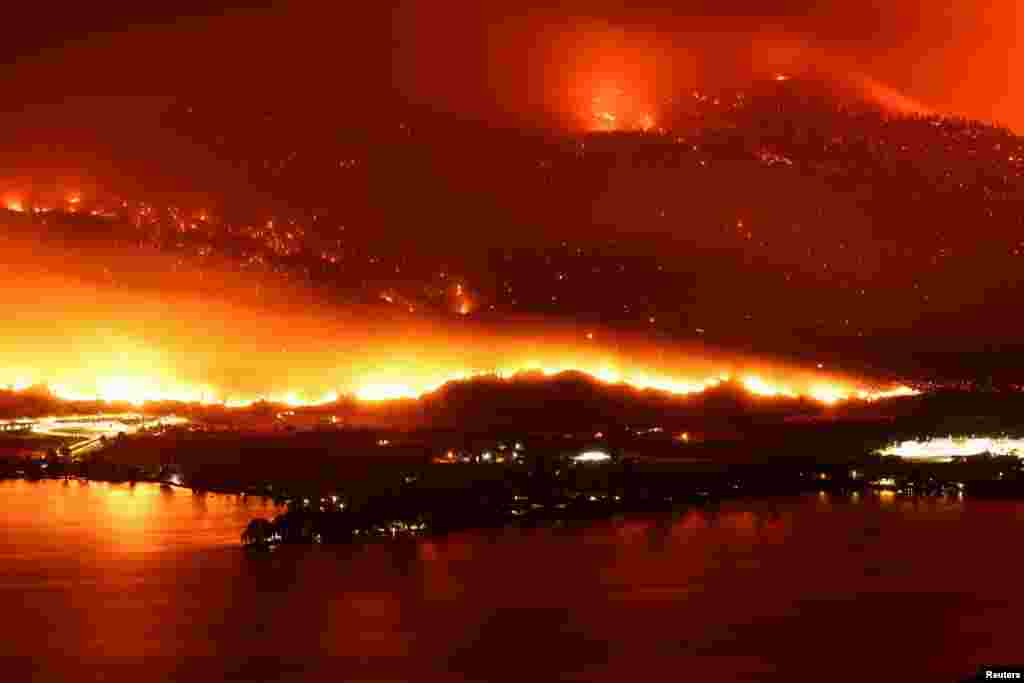 A long exposure image shows the Eagle Bluffs Wildfire, which crossed the border from the U.S. state of Washington, and prompted evacuation orders in Osoyoos, British Columbia, Canada, July 30, 2023.