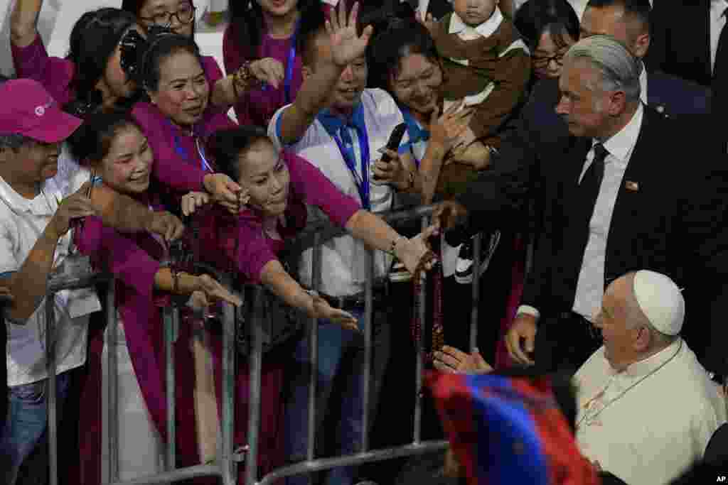 Pope Francis greets participants as he arrives to preside over a mass at the Steppe Arena in the Mongolian capital Ulaanbaatar.