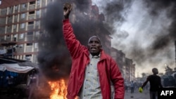 Mfuasi wa upinzani akiwa ameshika jiwe wakati akikabiliana na polisi huko Mathare , Nairobi Machi 27, 2023. Picha na Luis Tato / AFP.