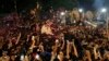 Pendukung Imran Khan melemparkan kelopak mawar ke arah kendaraan yang membawa mantan perdana menteri Pakistan itu untuk menyambut kedatangannya di rumahnya di Lahore, Pakistan, 13 Mei 2023. (Foto: AP)