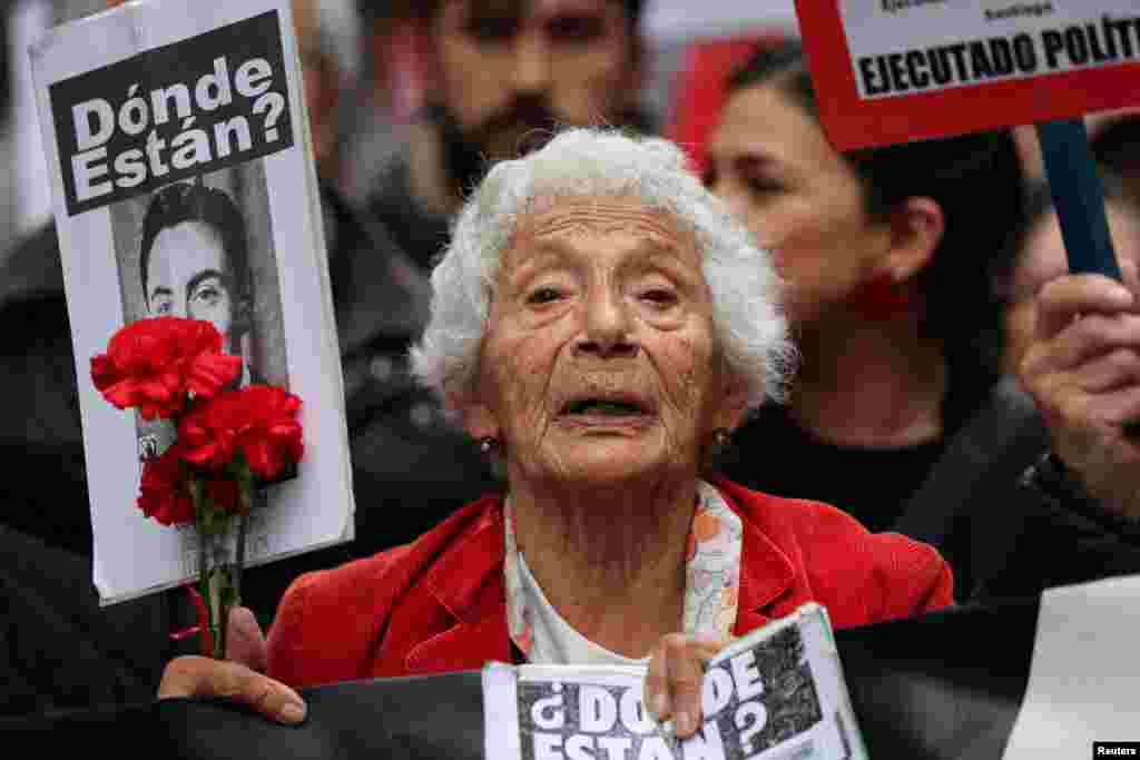 A woman looks on as demonstrators attend a rally-march ahead of the 50th anniversary of the 1973 Chilean military coup, in Santiago, Chile.