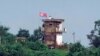 ແຟ້ມຮູບ-ທະຫານເກົາຫຼີເໜືອຄົນນຶ່ງ ຢືນຢູ່ປ້ອມຍາມກອງທັບ ຂອງເກົາຫຼີເໜືອ ໃນຂະນະທີ່ທຸງຂອງເກົາຫຼີເໜືອ ປິວໄປມາຕາມລົມ, ຮູບພາບທີ່ຖ່າຍຈາກເມືອງ ເປຈູ, ເກົາຫຼີໃຕ້, ວັນທີ 24 ກໍລະກົດ 2024.
