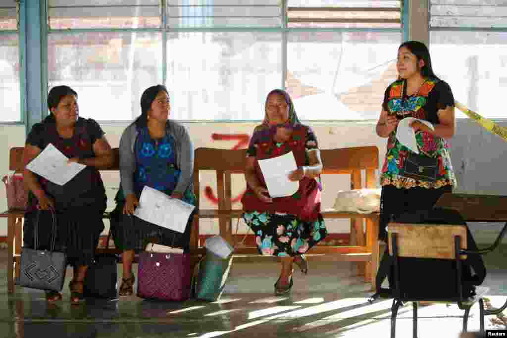 Trabajadores electorales en San Bartolomé Quialana se preparan para la jornada electoral en un centro de votación.
