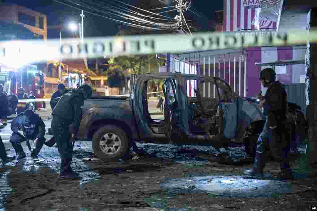 Police inspect a truck that exploded outside an office used by the government's National Service for Attention for People Deprived of Liberty (SNAI), which runs the jail system, in Quito, Ecuador.