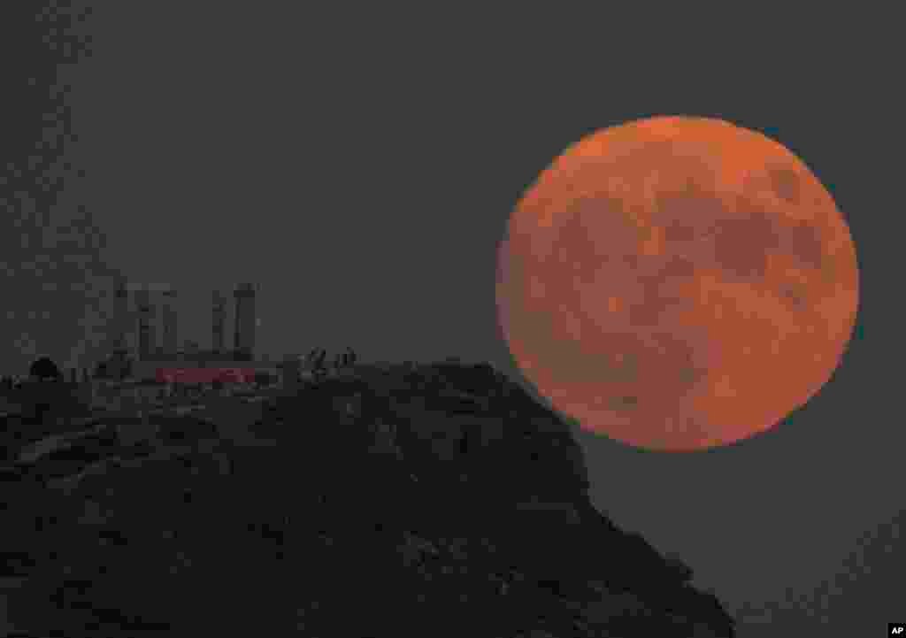 The supermoon rises behind the ancient temple of Poseidon at Cape Sounion, about 70 kilometers (45 miles) south of Athens, Greece, Aug. 30, 2023.