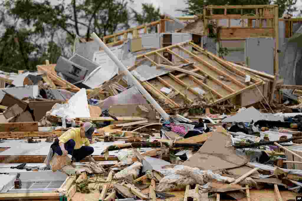 Valerie Bernhardt looks through debris at her stormed damaged home in Columbia, Tennessee. A wave of dangerous storms began crashing over parts of the South, a day after severe weather with damaging tornadoes killed at least three people in the region. 