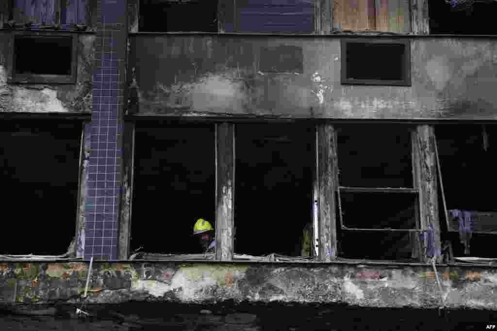 A firefighter works at the site where a shelter for homeless people caught fire, leaving at least 10 victims, in Porto Alegre, Brazil.