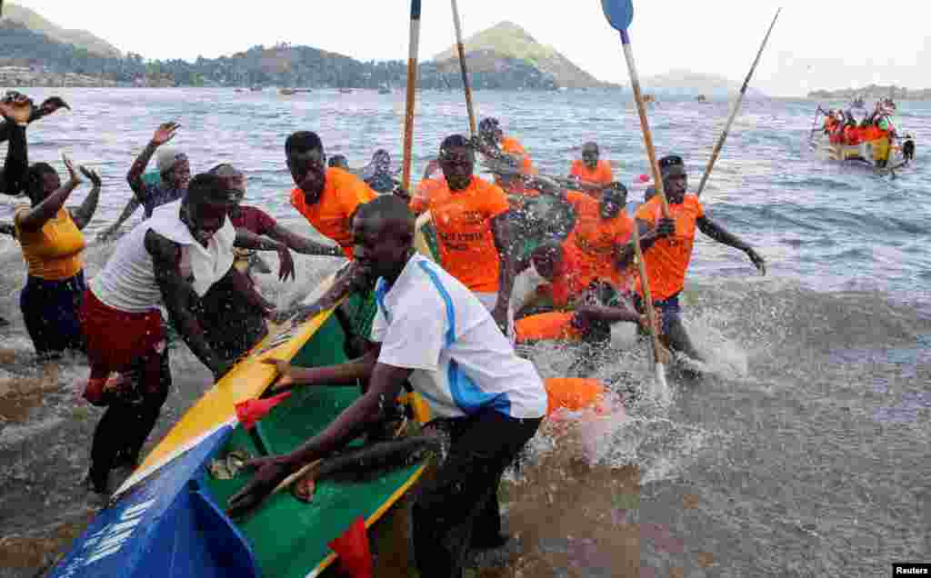 Revelers cheer participants during the traditional Kafuke boat-racing festival, as part of the Christmas celebrations, in Lake Victoria at Budalangi's Marenga beach in Port Victoria of Bunyala Sub-County of Busia, Kenya.