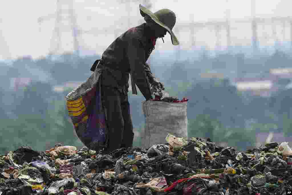 A ragpicker looks for recyclable items in a pile of garbage at a landfill in Depok on the outskirts of Jakarta, Indonesia.
