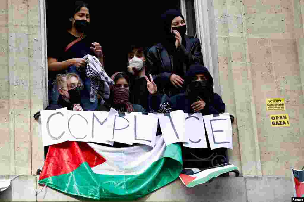 Masked youths take part in the occupation of a building of the Sciences Po University and block the entry in support of Palestinians in Gaza, in Paris, France.