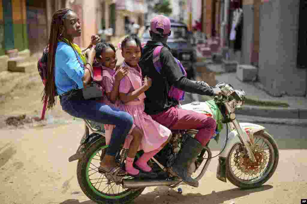 People ride on a motorcycle in Cap-Haitien, Haiti, April 17, 2024.