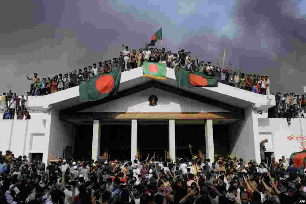 Anti-government protesters display Bangladesh's national flag as they storm Prime Minister Sheikh Hasina's palace in Dhaka, Aug. 5, 2024. Bangladesh army chief Waker-Uz-Zaman spent nearly four decades rising to the top of the military and said he was "taking full responsibility" after Prime Minister Sheikh Hasina was ousted and fled.