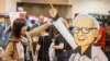 Hami Liu dari Taiwan berpose untuk foto dengan potongan karton Warren Buffett saat Berkshire Bazaar of Bargains di CHI Health Center pada Jumat, 5 Mei 2023. (Chris Machian/Omaha World-Herald via AP)
