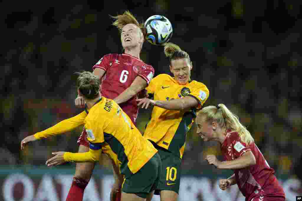 Denmark's Karen Holmgaard, top left, and Australia's Emily Van Egmond, top right, jump for the ball during the Women's World Cup round of 16 soccer match between Australia and Denmark at Stadium Australia in Sydney.