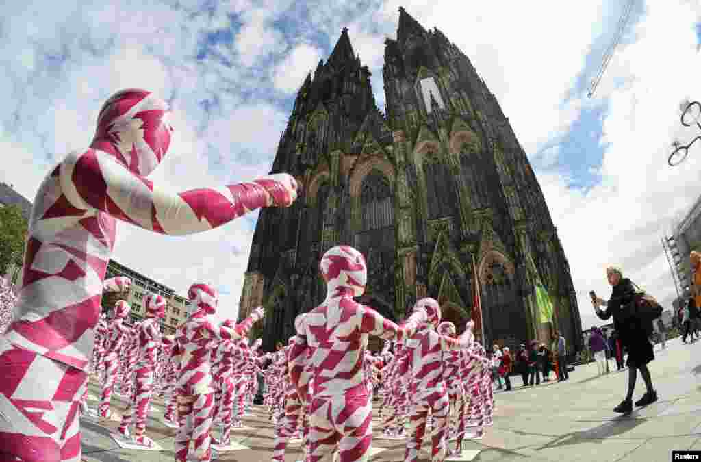 A view of children mannequins wrapped in purple and white barricade tape placed in front of the Cologne Cathedral, installed there by German artist Dennis Josef Meseg, called "Shattered Souls - in a Sea of Silence", to protest against the abuse scandals in the Catholic Church in Cologne, Germany. 