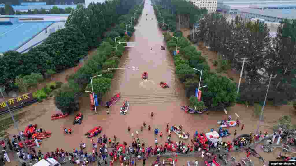 Rescue workers and boats are seen along a flooded road at an industrial development zone, following heavy rainfall in Zhuozhou, Hebei province, China, Aug. 2, 2023.