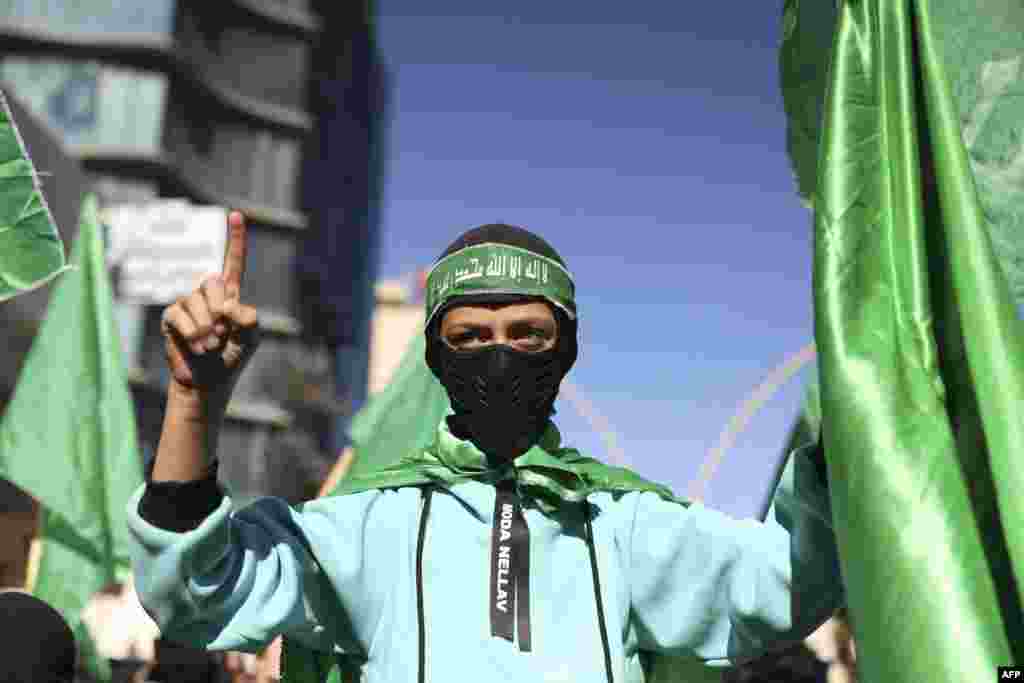Demonstrators lift flags of the Palestinian Hamas group during a rally after the Friday prayer in Hebron city in the occupied West Bank, protesting Israel's ongoing war against Hamas in Gaza.