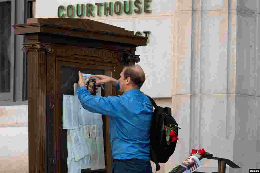 A supporter places roses and a photo of Fulton County District Attorney Fani Willis near the entrance of the Lewis R. Slaton Courthouse in Atlanta, Georgia, after a Grand Jury brought back indictments against former president Donald Trump and 18 of his allies in their attempt to overturn the state's 2020 election results.
