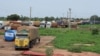 Trucks carrying food, humanitarian aid, and industrial equipment wait due to sanctions imposed by Niger's regional and international allies, in the border town of Malanville, Benin, Aug. 18, 2023.