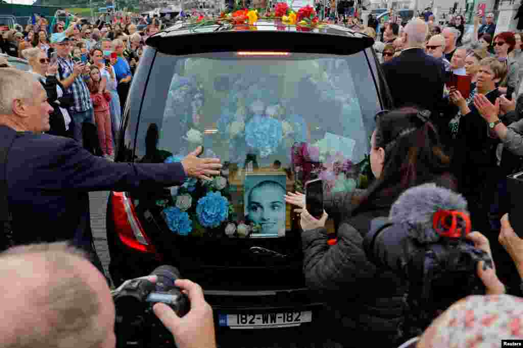 A hearse carrying the coffin of late Irish singer Sinead O'Connor passes by during her funeral procession as fans line the street to say their last goodbye to her, in Bray, Ireland, Aug. 8, 2023.