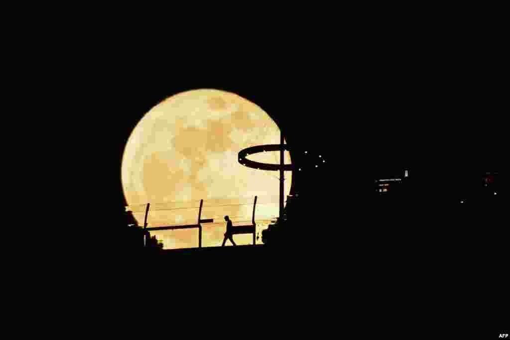 A Super blue moon rises behind Marina Bay Sands observation deck in Singapore.