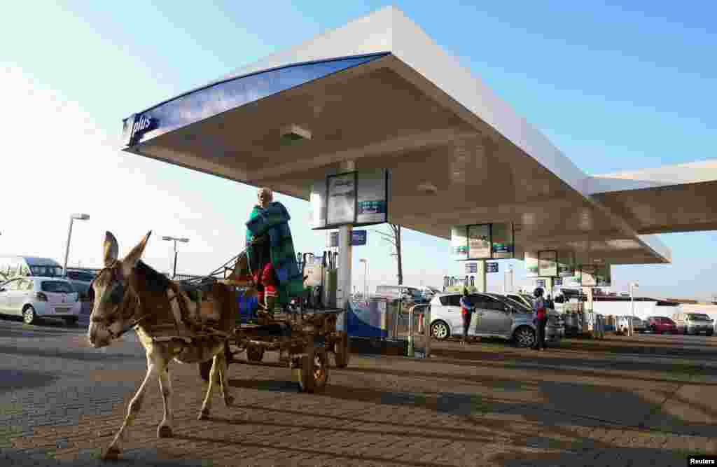 A man leaves a petrol station after checking the tire pressure on his donkey cart in Soweto, Johannesburg, South Africa.