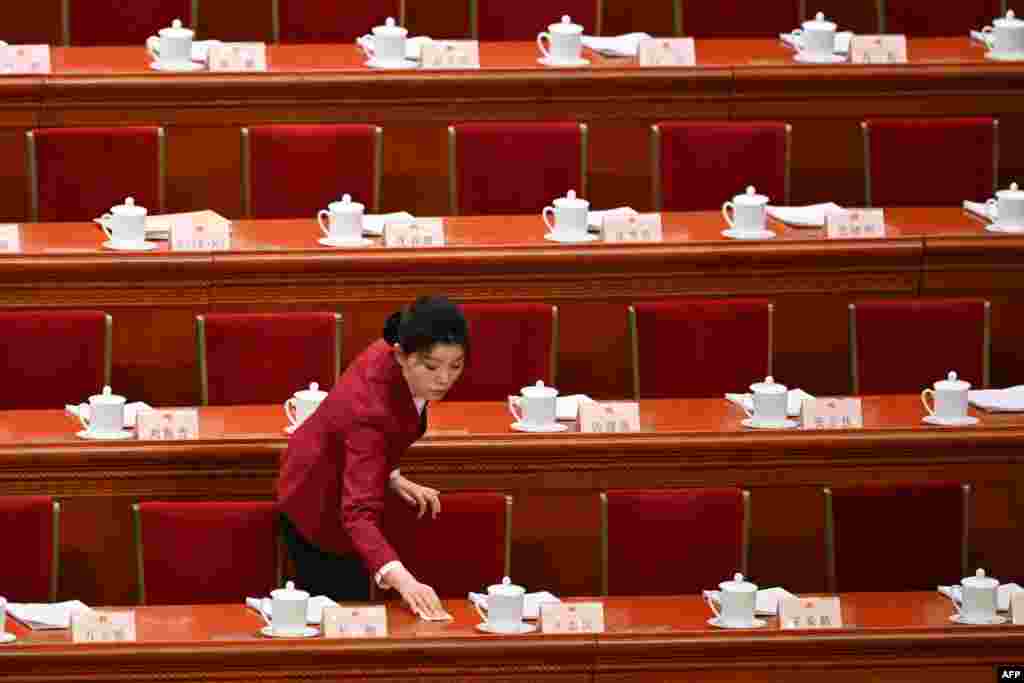 An attendant cleans before the second plenary session of the 14th National People's Congress (NPC) at the Great Hall of the People in Beijing.