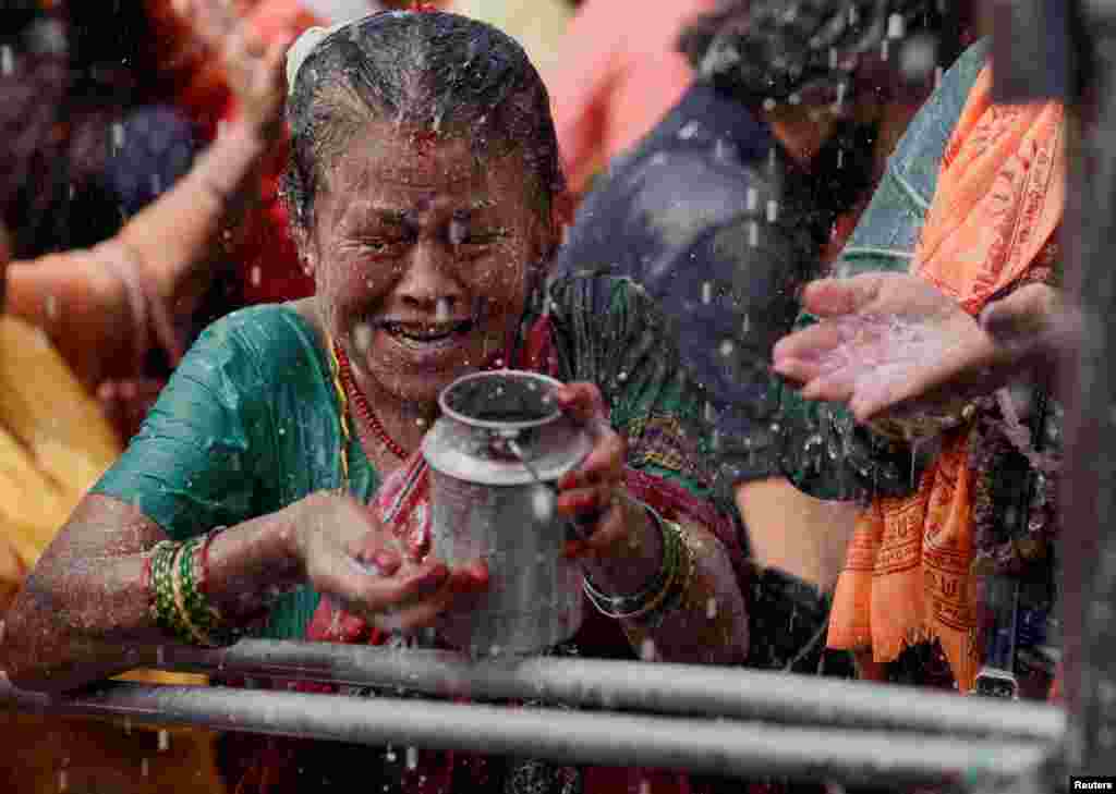 A devotee collects "Panchamrit," a mixture of milk, water, yoghurt, jaggery and honey, at Makhan Pashupatinath temple during the Shrawan Sombar festival in Kathmandu, Nepal.
