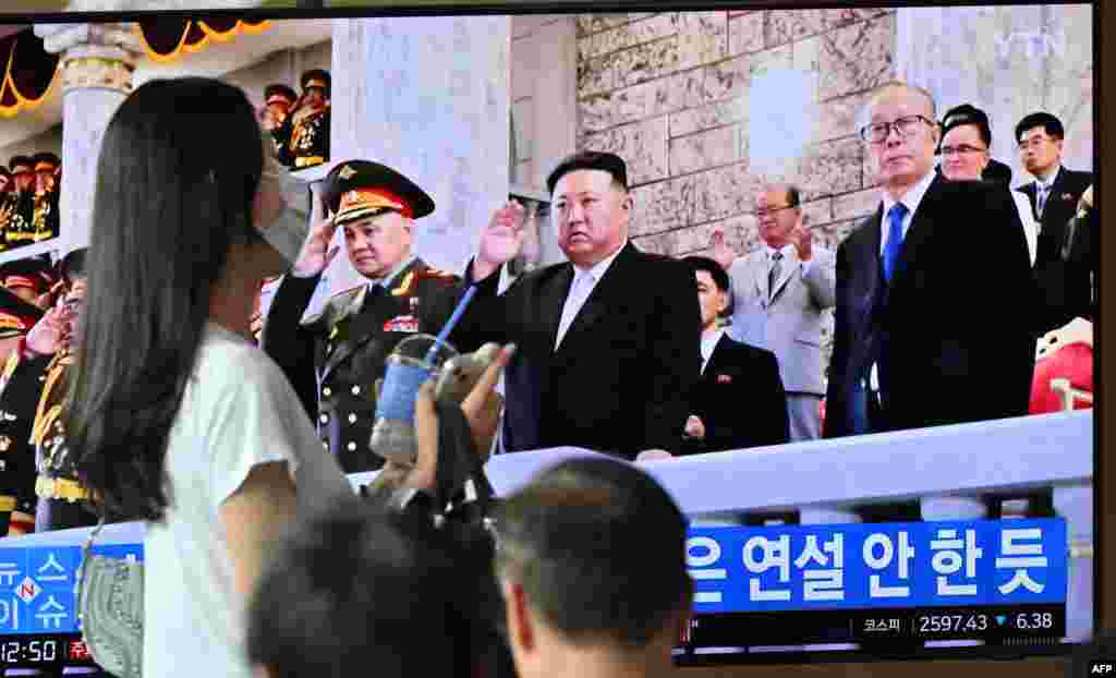 A woman walks past a television screen showing a news broadcast with an image of North Korean leader Kim Jong Un attending a military parade held in Pyongyang to mark the 70th anniversary of the Korean War armistice, at a railway station in Seoul. Kim Jong Un oversaw a North Korean military parade featuring new drones and Pyongyang's nuclear-capable intercontinental ballistic missiles.