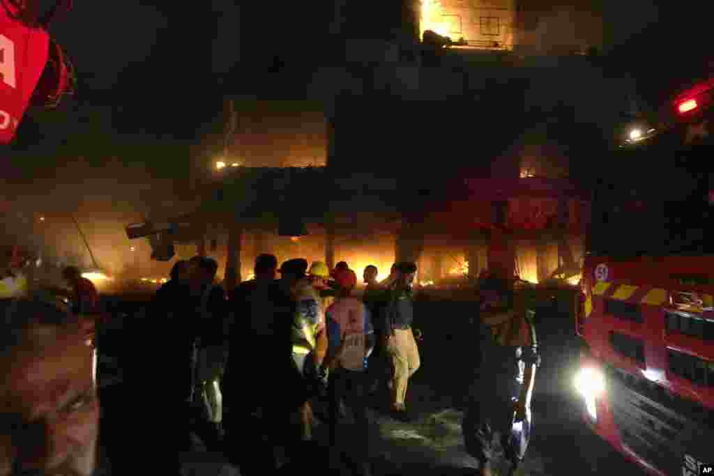 Firefighters struggle to contain a fire at a multi-story commercial building in Karachi, Pakistan. The massive fire broke out in the largest southern port city, killing a number of people and damaging several shops, police and rescue officials said. 
