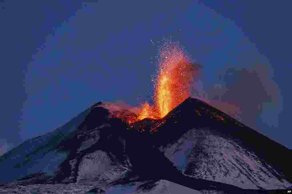 Lava erupts from snow-covered Mt. Etna volcano, Sicily, Italy.