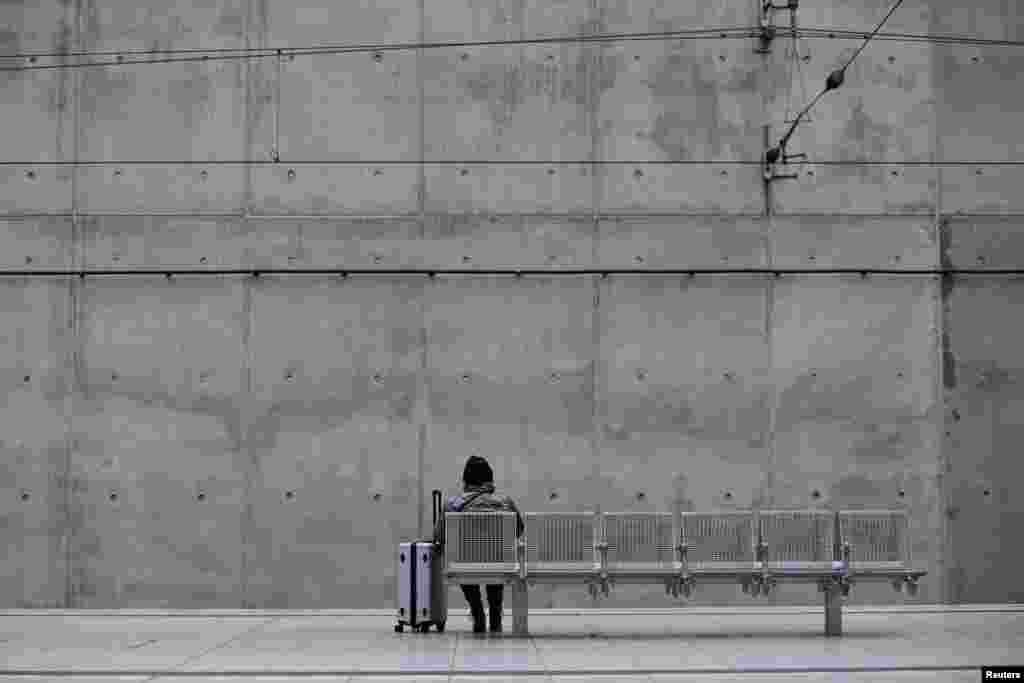 A passenger waits for a train during a strike by Germany's GDL train drivers union demanding wage increases and a shorter working week, at a train station at Cologne-Bonn Airport in Cologne, Germany.
