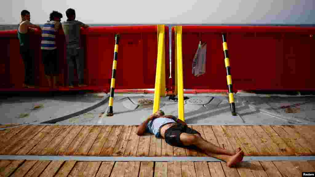 Migrants rest on board of NGO Proactiva Open Arms Uno rescue boat in central Mediterranean Sea.