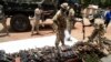 FILE - Nigerian soldiers take inventory on April 21, 2022, of small arms and light weapons recovered from bandits during an operation in north central Nigeria. 