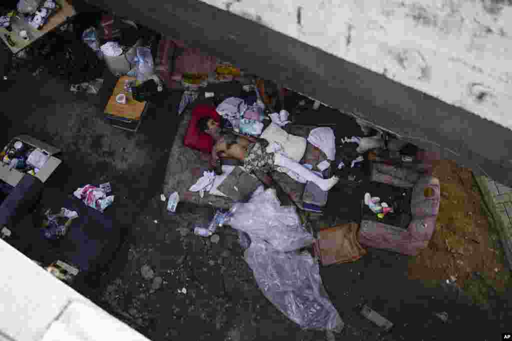 Homeless Cesar Ramirez lies on a mattress under a bridge in Caracas, Venezuela, Aug. 20, 2022.