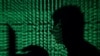 FILE - A man holds a laptop computer as cyber code is projected on him in this illustration picture taken on May 13, 2017.
