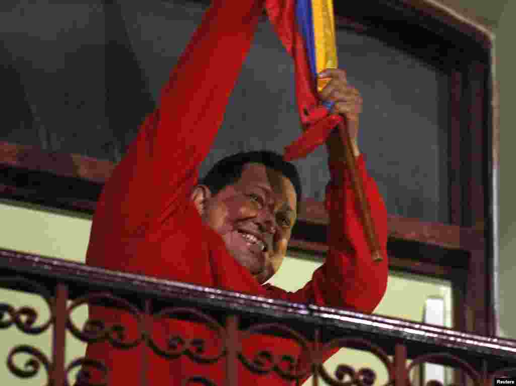 Tổng thống Venezuela Hugo Chavez cầm quốc kỳ trong lúc mừng chiến thắng trên ban-công dinh tổng thống Miraflores ở Caracas, ngày 7 tháng 10, 2012.
