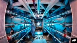 En esta imagen de 2012 proporcionada por el Laboratorio Nacional Lawrence Livermore, un técnico revisa una óptica dentro de la estructura de soporte del preamplificador en el Laboratorio Nacional Lawrence Livermore en Livermore, California.