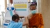 Seorang petugas kesehatan memberikan dosis vaksin AstraZeneca COVID-19 kepada seorang biksu Buddha di Kuil Nak Prok di Bangkok, Thailand, Jumat, 9 April 2021. (Foto: AP/Sakchai Lalit)