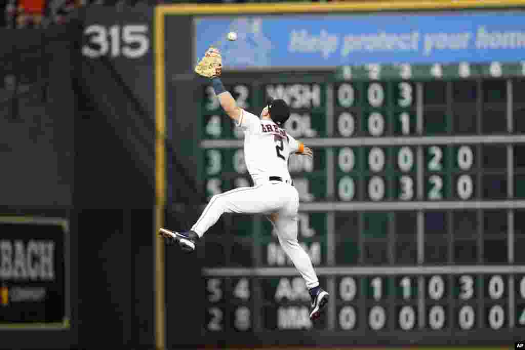 Houston Astros third baseman Alex Bregman tries to catch a single by Seattle Mariners' Adam Frazier during the sixth inning of a baseball game, May 3, 2022, in Houston, Texas.