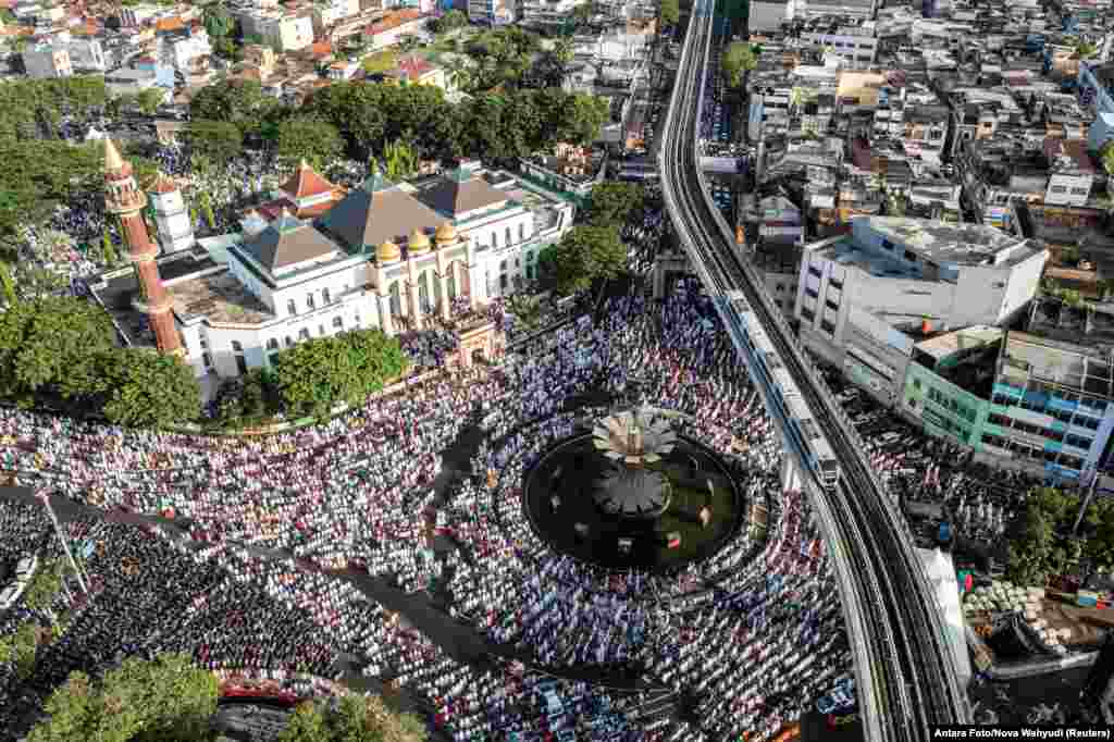 Muslims attend mass prayers at the Sultan Mahmud Badaruddin Jayo Wikramo Great Mosque during Eid al-Fitr, marking the end of the holy fasting month of Ramadan, in Palembang, South Sumatra province, Indonesia.