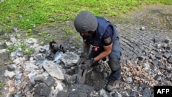 Stručnjak za eksplozive ispituje ostatke ruske rakete pale na teritoriju spomenika žrtvama totalitarizama, na obodu Harkova, 8. maja 2022.
