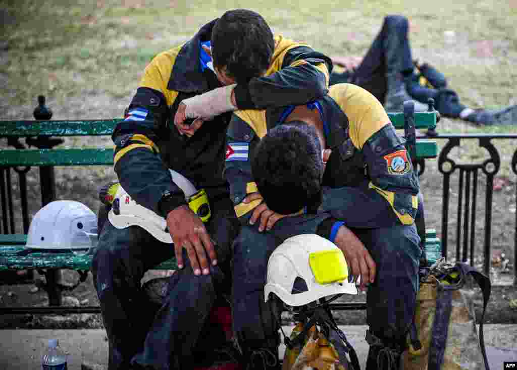 Members of the rescue brigade rest after a work shift at the Saratoga Hotel days after a huge blast wrecked the building, in Havana, Cuba.