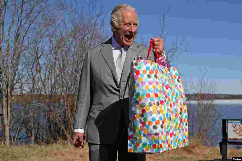 Britain's Prince Charles holds a bag as he reacts near the Great Slave Lake on the final day of his Canadian 2022 Royal Tour in Yellowknife, Northwest Territories, Canada, May 19, 2022.