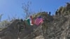 An Indian and U.S. army soldier, each carrying their respective countries' flags, run up a hill during joint Indo-U.S. military exercises in the Indian state of Uttarakhand, Nov. 30, 2022.
