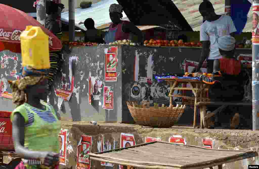 Electoral posters are pictured as vendors sell their wares at the central market in Gorongosa, central Mozambique, Nov. 19, 2013.