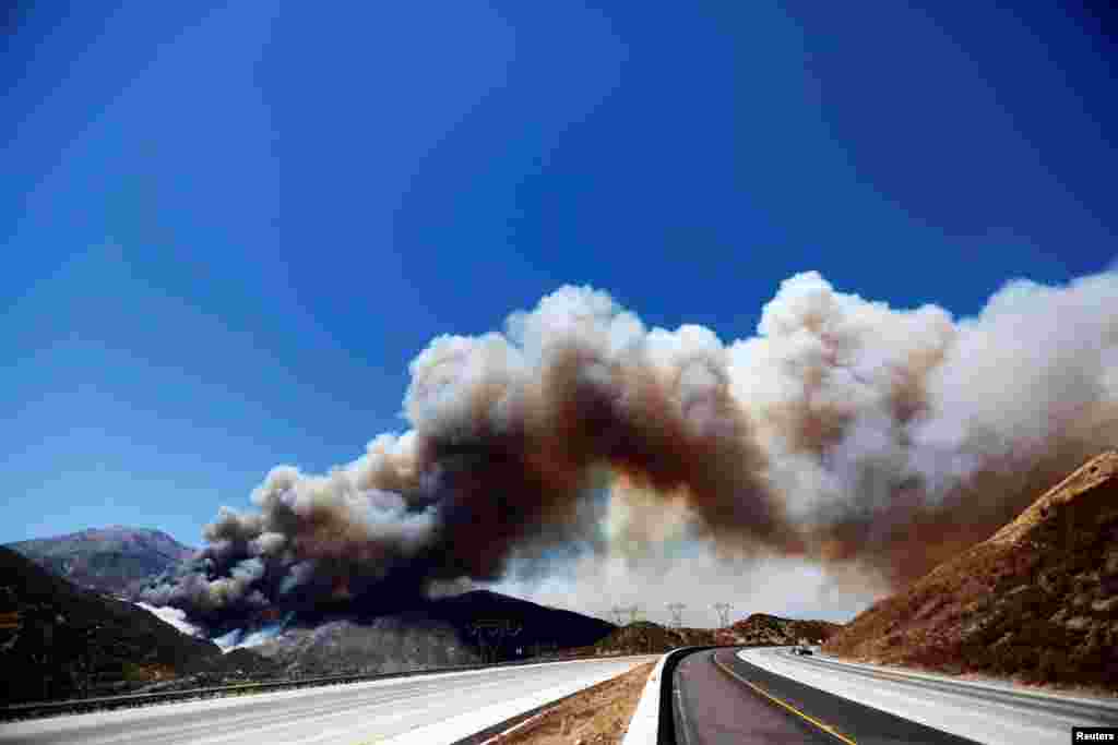 Asap tebal akibat kebakaran hutan tampak dari jalan raya Cajon Pass di San Bernardino, California.